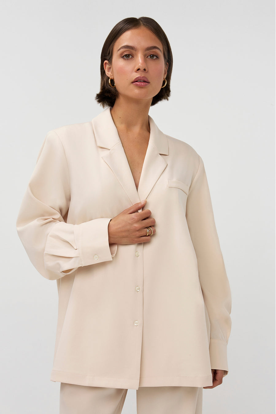 Beige blazer Noomi van Studio Amaya, gedragen door een model, met knopen en reverskraag, voor een stijlvolle uitstraling