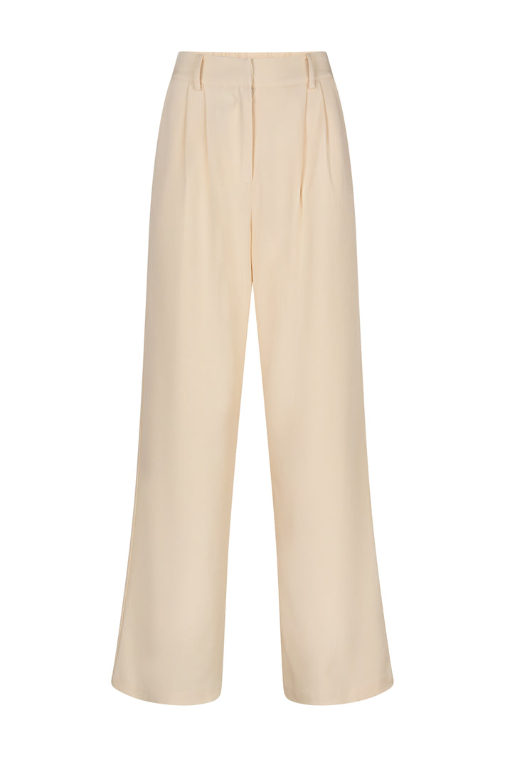 Lichte beige Jackie broek van Studio Amaya met elastische tailleband en rechte pasvorm, gedragen door een model.