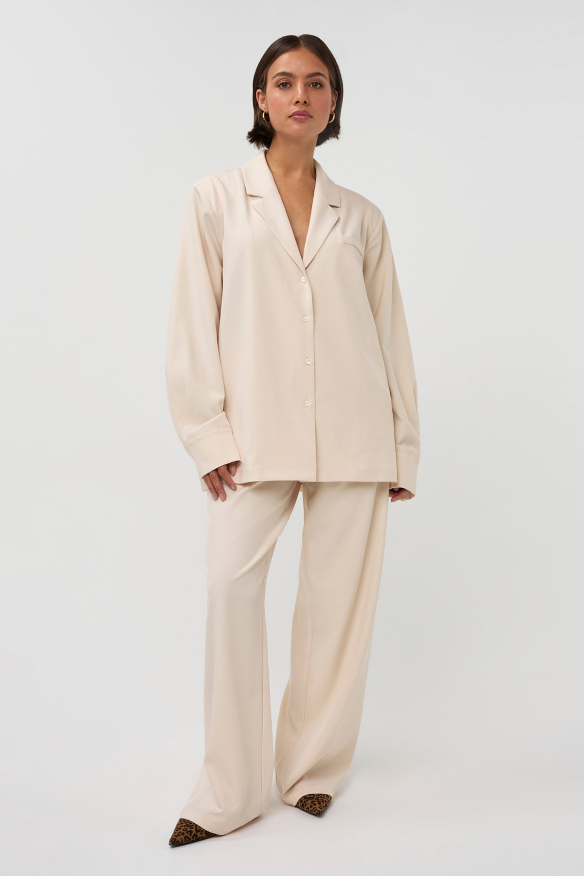 Beige blazer Noomi van Studio Amaya met kraag en knopen, gedragen door een model op een neutrale achtergrond.