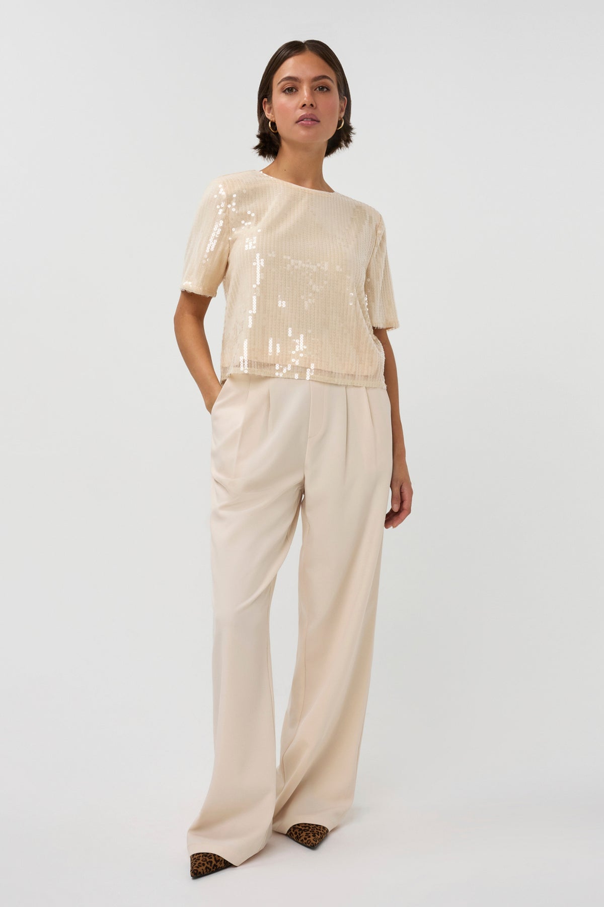 Lichte beige broek Jasmin van Studio Amaya, getoond op een model, met een losse pasvorm en comfortabele tailleband.
