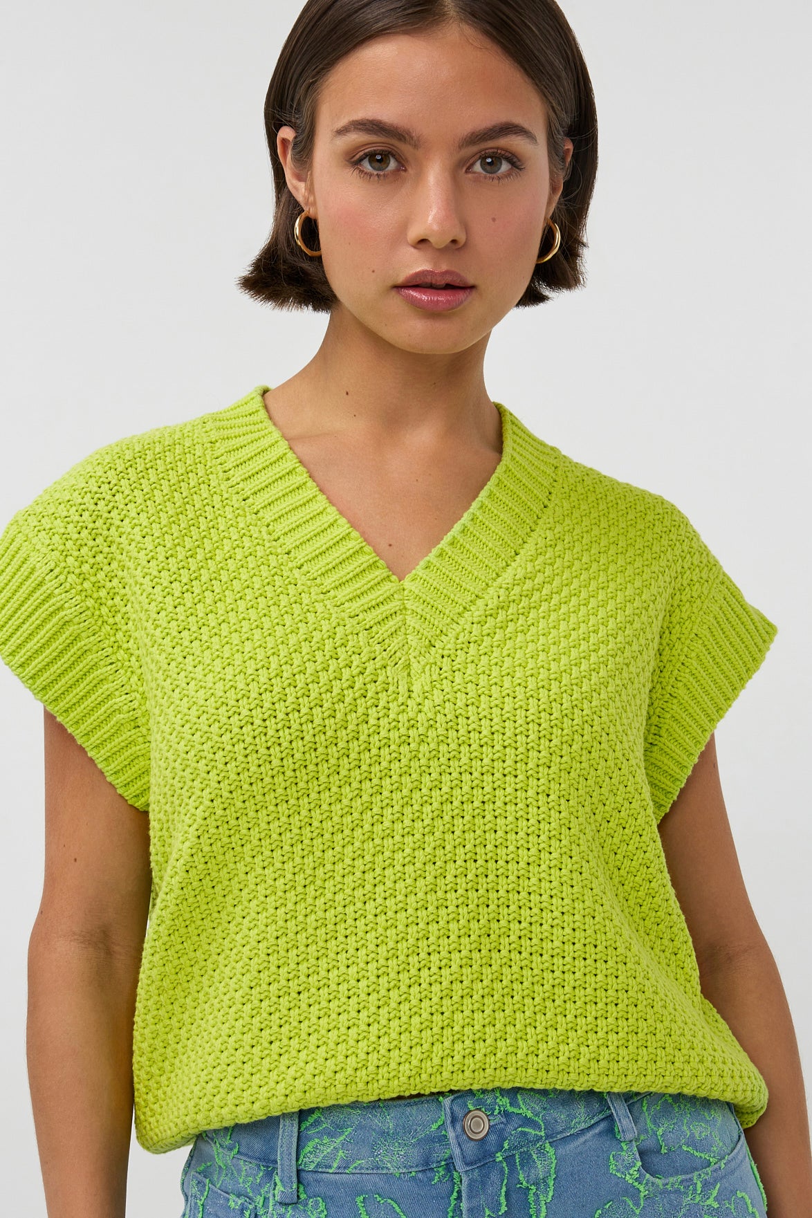 Limegroen top Ardina van Studio Amaya, met zachte stof en stijlvolle pasvorm, gedragen door een model.