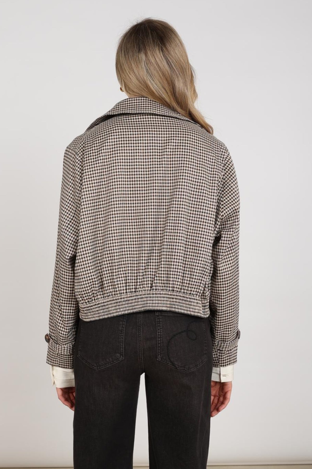 Nukus Dahlia Check Sand Chocolate jas met ruitpatroon, korte mouwen en knoopsluiting, gelegen op een witte achtergrond.