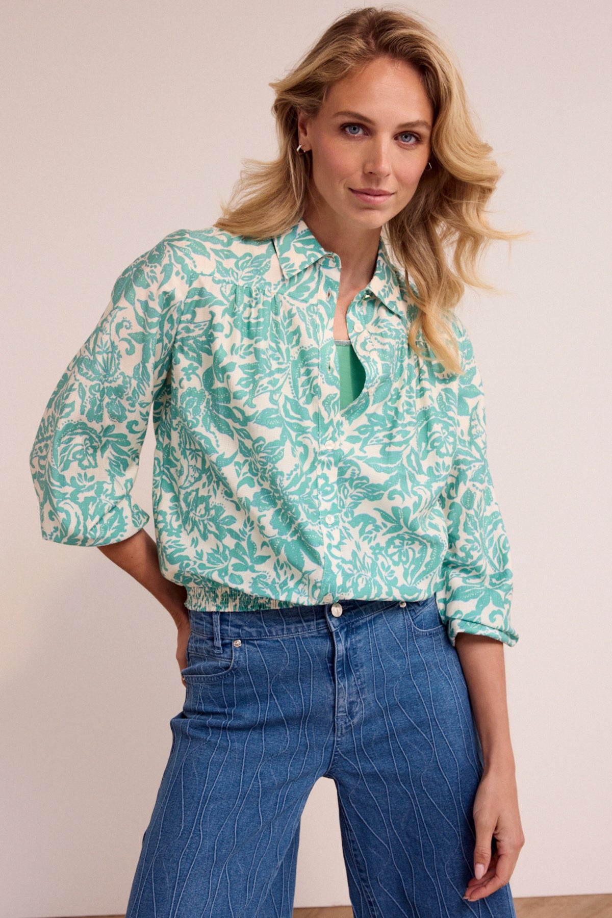 Blouse Tramontana Emerald Flourish met elegante bloemenprint en V-hals, gedragen door een model.