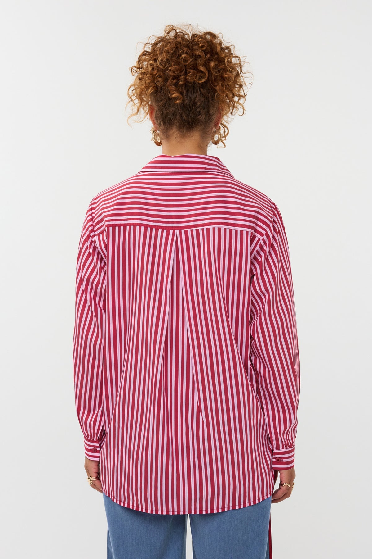 Rode blouse Judy van Ydence, met lange mouwen en losse pasvorm, zichtbaar op de afbeelding.