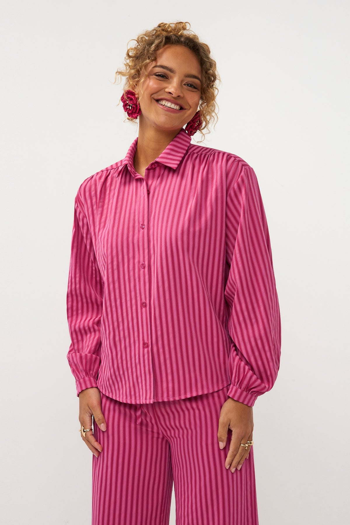 Roze blouse Madelena van Ydence met vloeiende stof en lange mouwen, gedragen door een model op een witte achtergrond.