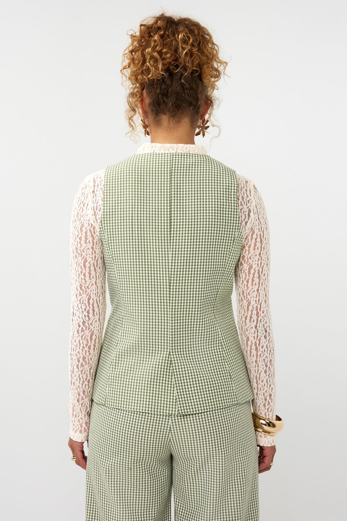 Groen geruit Ydence Jette gilet met knopen en zakken, gedragen door een model.