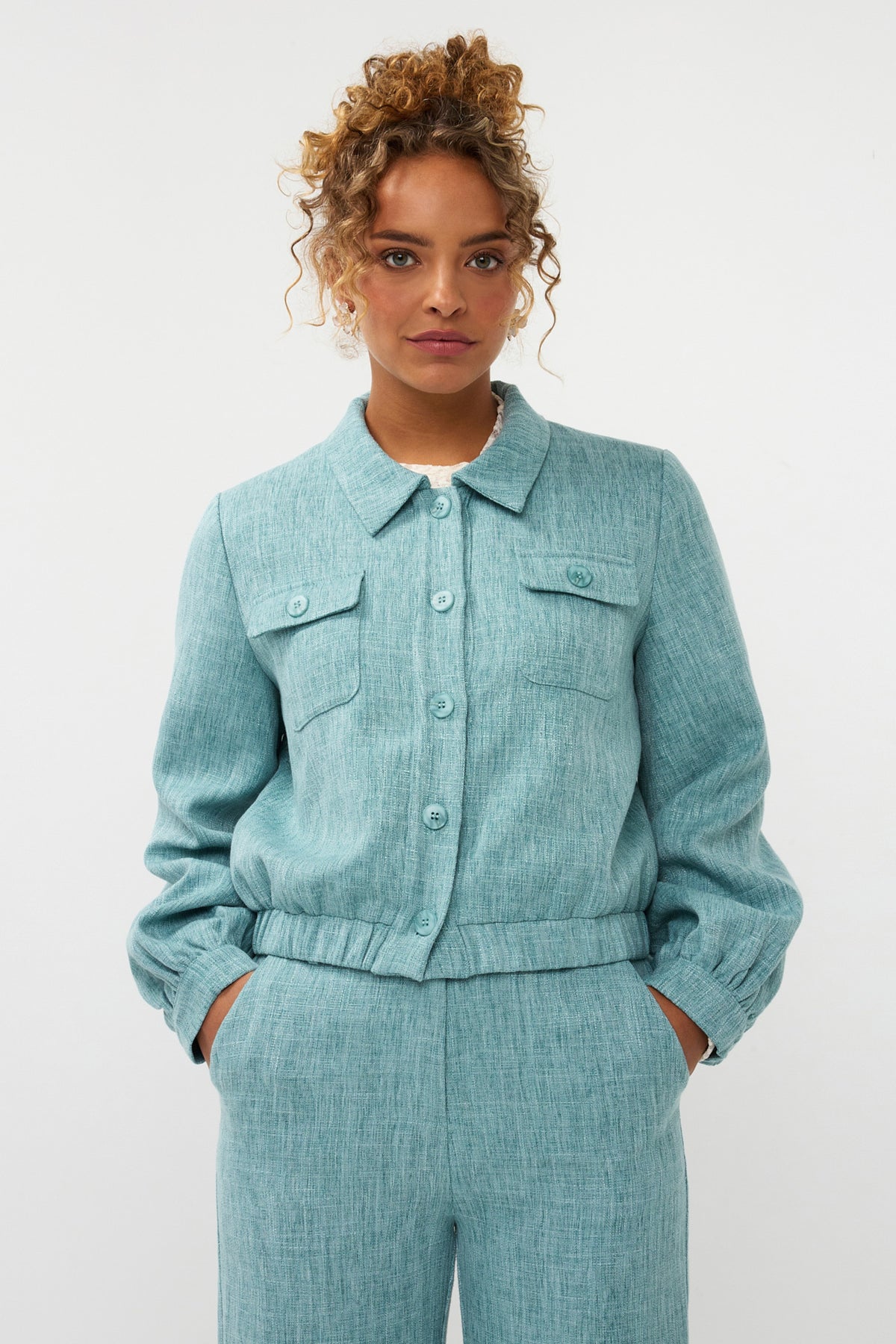 Ydence Jinte jas in turquoise melange met capuchon en ritssluiting, zachte stof en modieuze pasvorm.