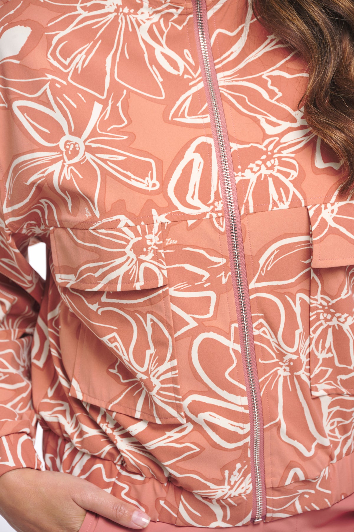 Zoso Travel Jacket Jenny Desert Rose, lichtgewicht damesreiskleding met roze kleur en praktische zakken, close-up van de jas.